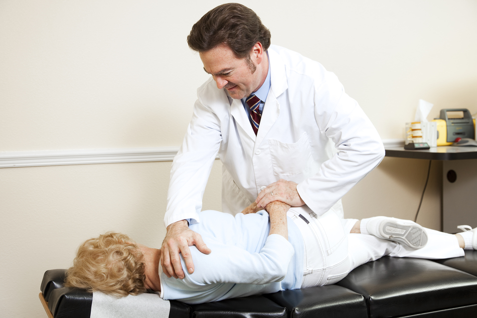 Chiropractor adjusting female patient